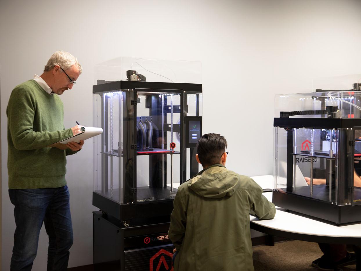 3 Personen überwachen den 3D Druck vom Raise3d Pro2 Plus
