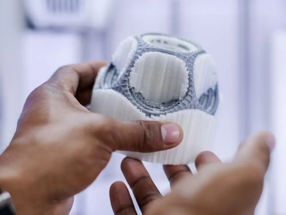 Ein paar Hände hält ein 3D gedrucktes Objekt