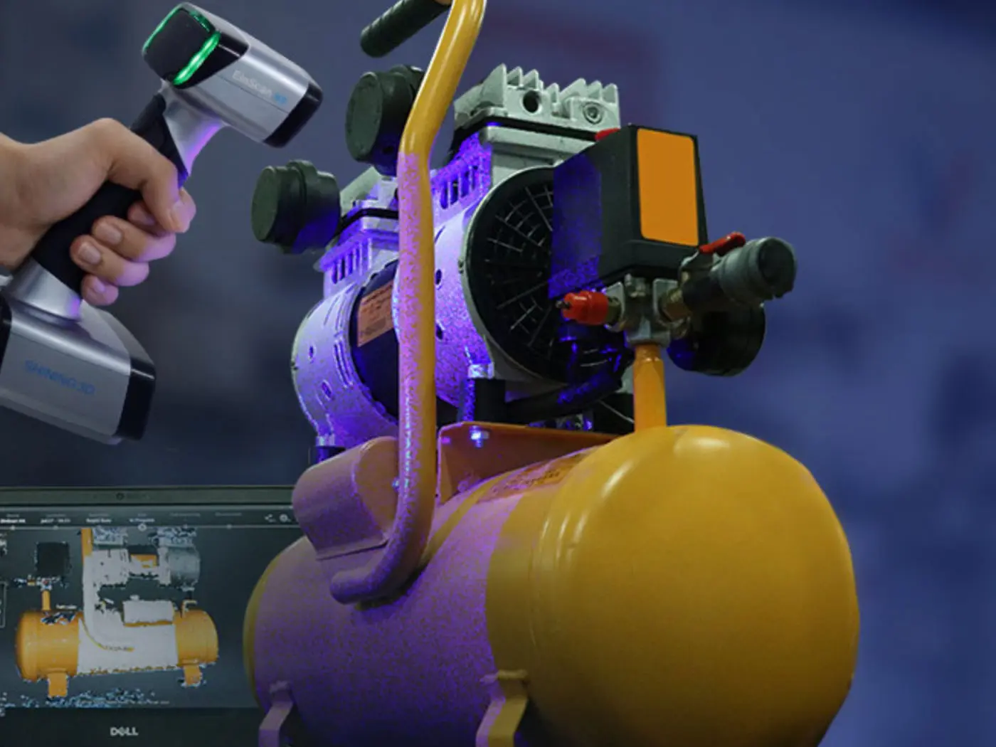 Ein Kompressor wird mit einem Hand 3D Scanner eingescannt und auf dem Bildschirm von Laptop im Hintergrund sieht man den 3D Scan