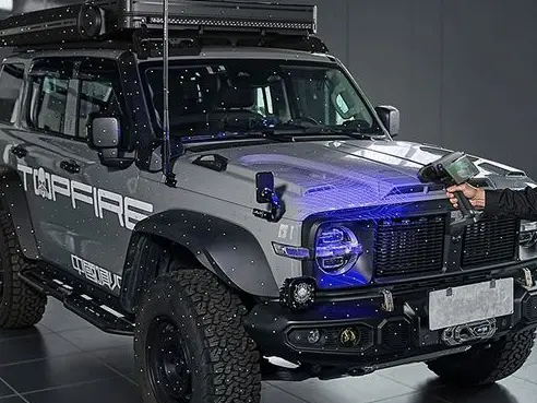 Ein Geländewagen überdeckt mit Referenzpunkten wird gerade mit einem 3D Scanner eingescannt