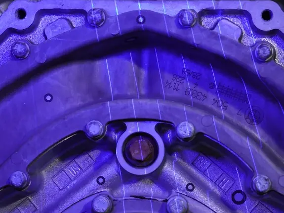 Ein metallisches Bauteil leuchtet Blau von dem Lasergitter es 3D Scanners